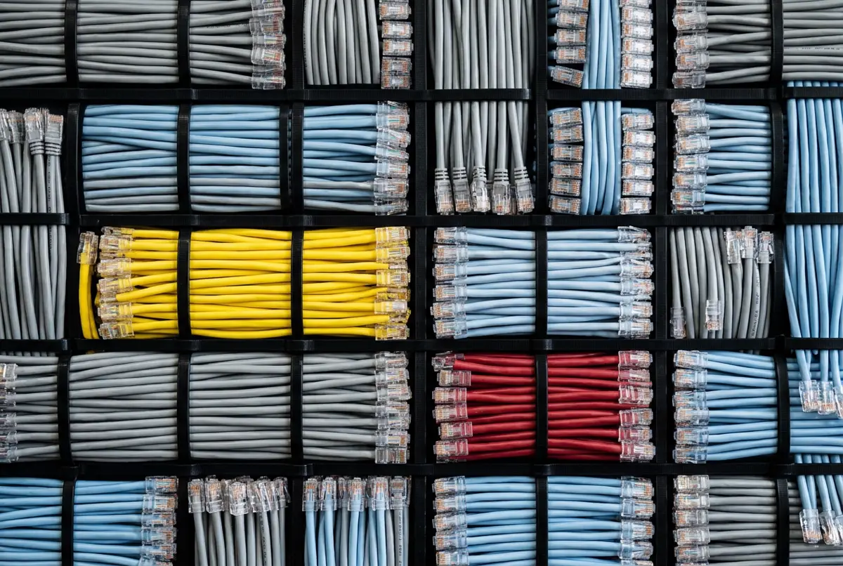 Network cables in blue, grey, yellow and red bundled into a grid of unequal rectangles